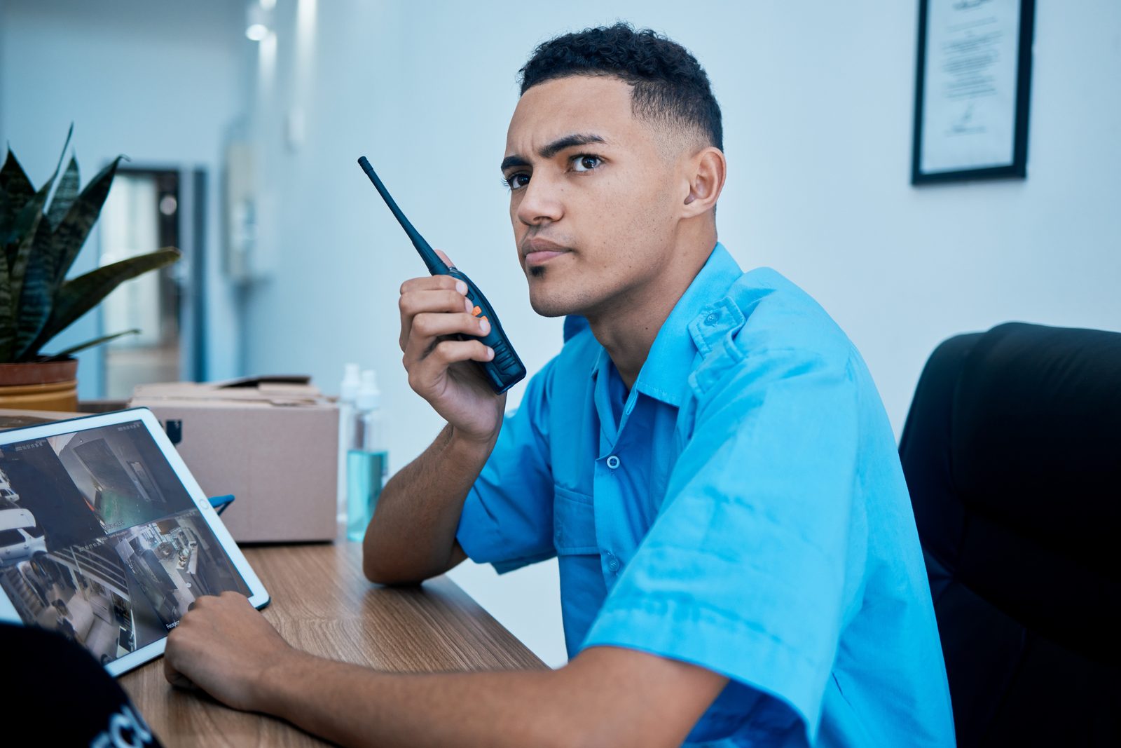 Porteiro monitorando câmeras e comunicando por rádio